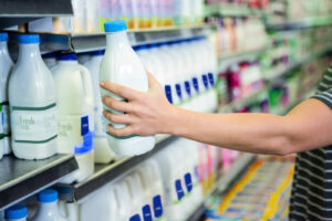 person reaching for milk in a refrigerator