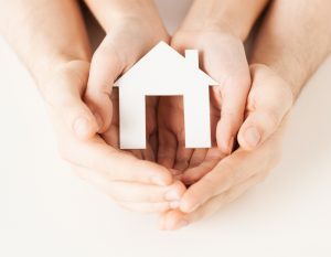 Pairs of hands holding a house symbol