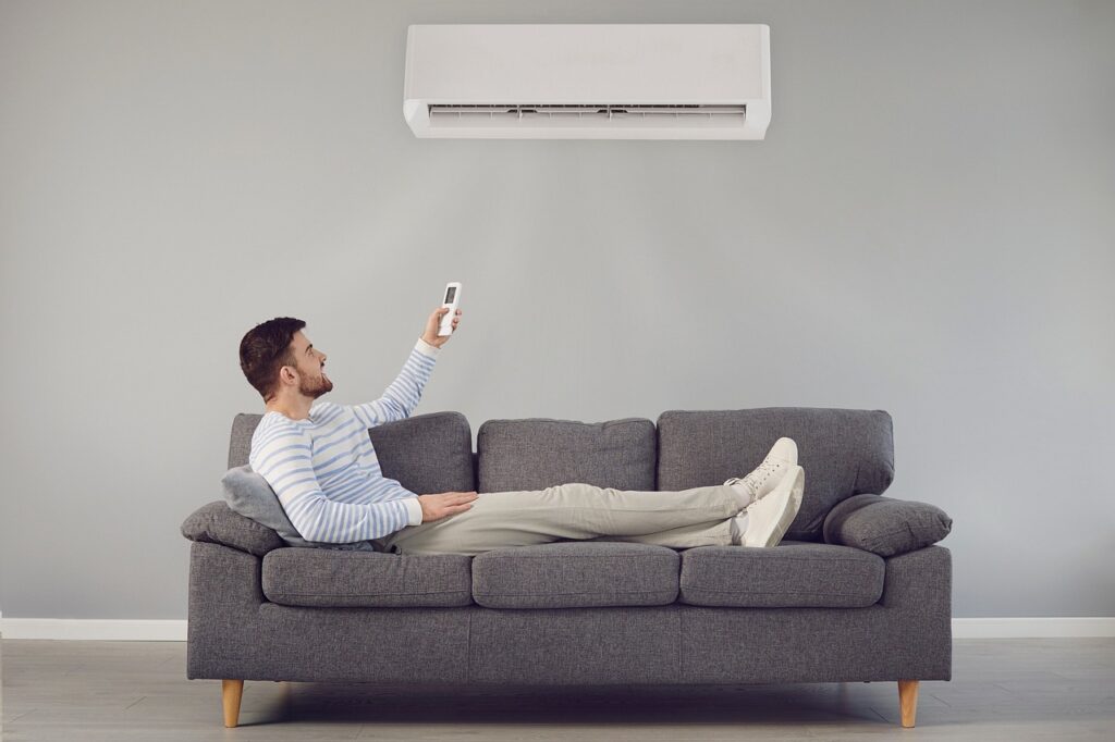 man sitting in couch with air conditioner