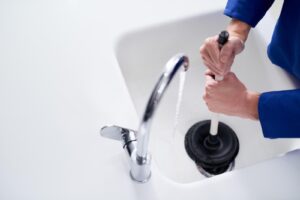 Man unblocking bathroom drain