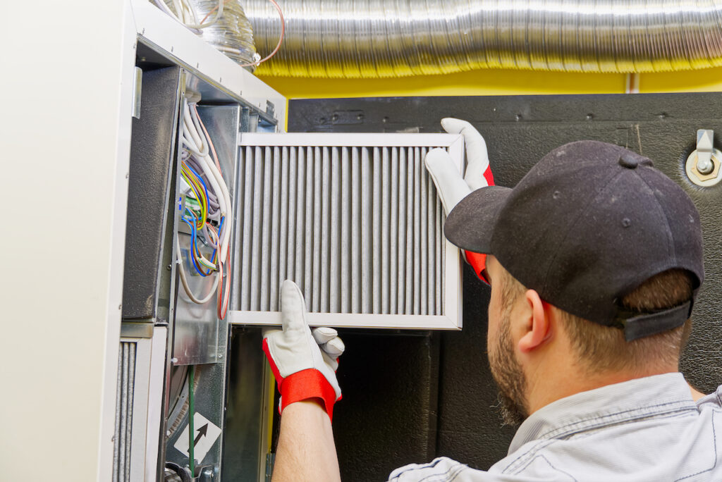 Man changing air filter in air conditioning unit